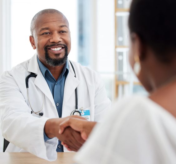 Happy doctor, patient and handshake in healthcare visit, consultation or agreement at hospital. Black man, medical professional shaking hands with woman client for consulting, checkup or appointment.